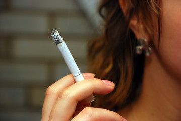 Girl holding smoking cigarette in hand