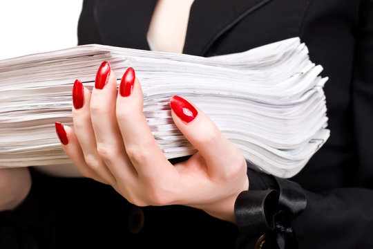 Businesswoman holding heap of papers closeup