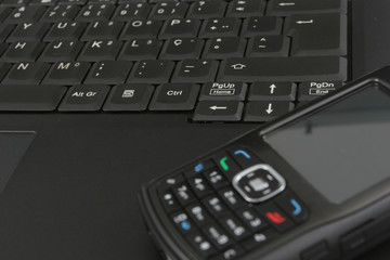 Cellphone isolated over laptop keyboard