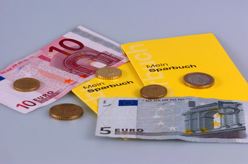 Sparbuecher mit Euromuenzen und Banknoten