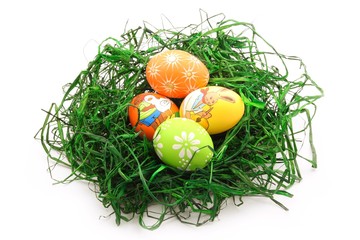 Four easter eggs in a nest isolated on white