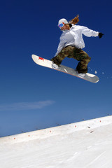 woman snowboarder in flight with sky behind