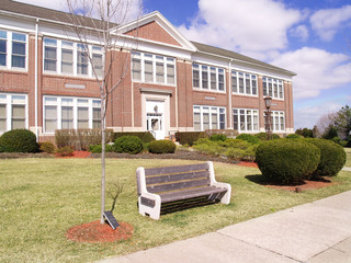 park bench in front of a red brick building