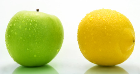A green apple and a lemon with water drops