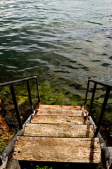 Old grungy stairs leading down to a lake