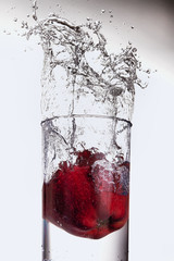 Apple splashing into a glass of water