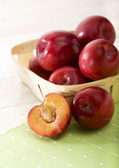 red plums in small basket