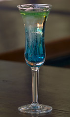 A strong alcoholic cocktail is in a high wineglass