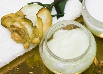 cream, towel with rose on yellow background