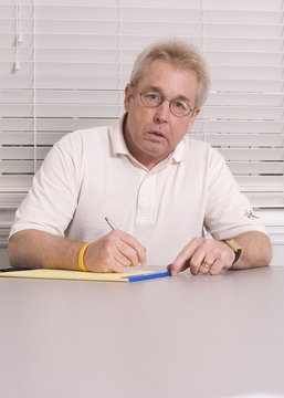 man writing on legal pad