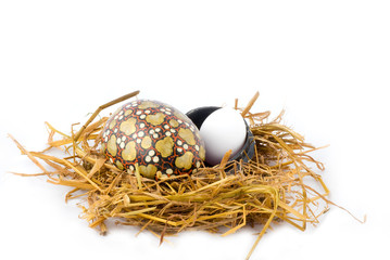 a egg and acandy egg in a hay nest