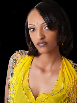 Portrait Of Young Black Woman In Yellow Top With Coins