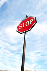 Stop sign on a blue sky from below.