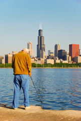 Retiree is fishing early morning against Chicago skyline