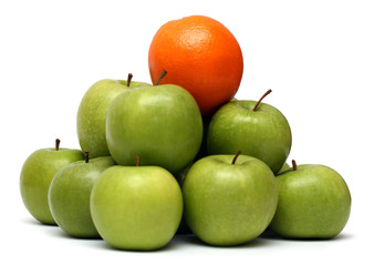 domination concepts - orange on pyramyd of apples