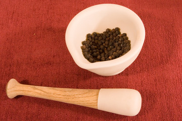 Mortar and Pestle with Black Peppercorns on Red Cloth