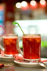 Cup of fruit tea on abstract blurred background (shallow DoF)