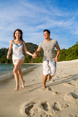 loving couple having fun running by the beach