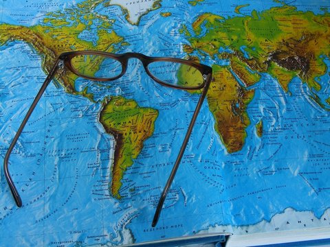 Making a journey plans over the opened atlas and maps