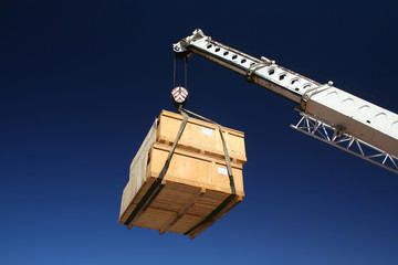 Wooden crates being moved by crane.