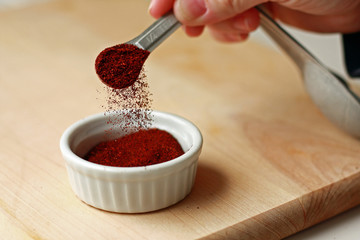 Spice measured with measuring spoon on cutting board
