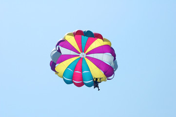 Multi coloured parachute over the blue sky