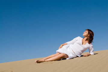 Fototapeta na wymiar Beautful woman lying in the sand