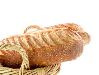 Sour dough bread in wicker basket on white