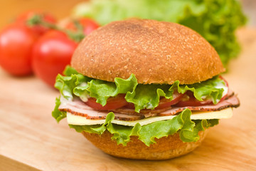 Ham & Swiss sandwich with fresh vegetables in background