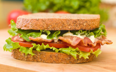 BLT sandwich with fresh veggies in the background