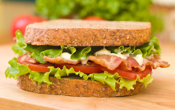 BLT sandwich with fresh veggies in the background