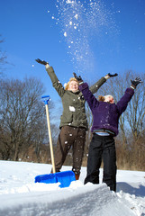 mother and her daughter throw up snow on a winter background