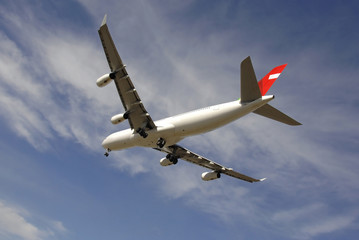 Jetliner landing against blue sky