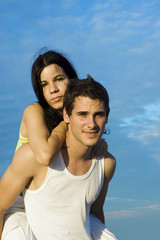 Portrait of young hispanic couple in piggyback outdoors