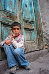 A boy sitting at the doorstep and thinking