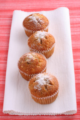 four cupcakes muffins on white and red place mats