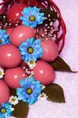 Obraz premium red easter eggs with blue flowers on basket