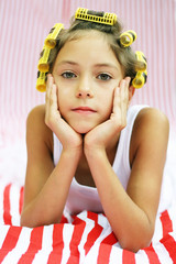 Beautiful girl with hair rollers on a stripy background