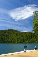 Fototapeta na wymiar pécheur, lac et ciel bleu