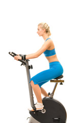 Fototapeta premium Beautiful young woman on exercise bicycle over white background
