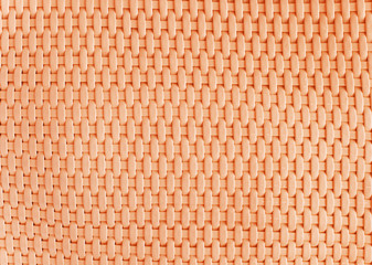 Background made of woven reddish plastic stripes
