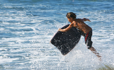 Young child in the air on his boogie board
