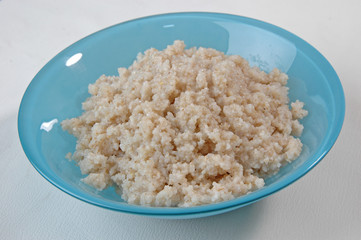 barley groats porridge in  plate on white