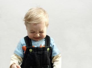 portrait offended small boy on light background