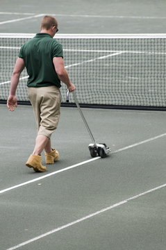 man prepping tennis court