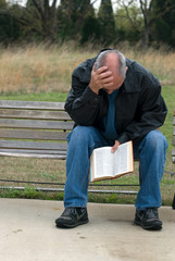 Sad man holding bible