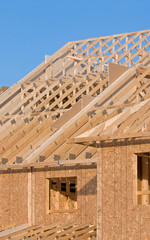 Roof structure of a new home set against clear sky