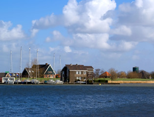 Fototapeta na wymiar Dutch village view with private yachts moored on front
