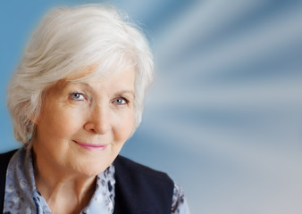  Charmante Seniorin auf blauem Hintergrund