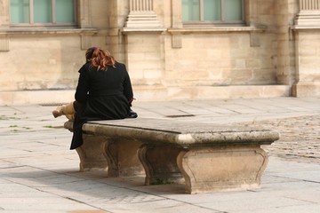 Jeune femme assise sur un vieux banc en pierre